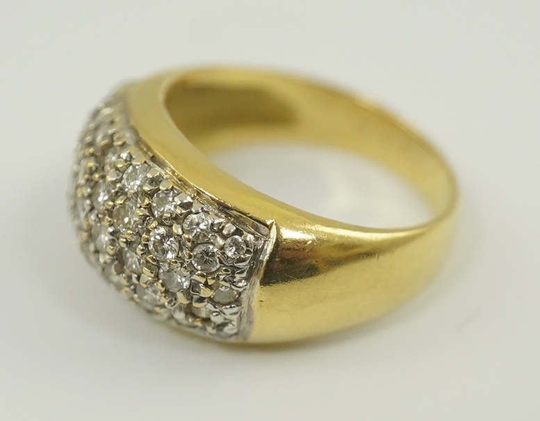 A modern 18k gold and diamond cluster set domed ring